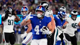 New York Giants' Cam Skattebo celebrating after scoring a touchdown on the football field.