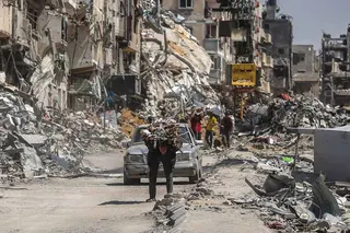 KHAN YUNIS, GAZA - APRIL 13: (EDITOR'S NOTE: Alternative crop of image # 2148520862) A man carries items on his back as people remove possessions from their homes following Israeli airstrikes on April 13, 2024 in Khan Yunis, Gaza. The Israeli military has scaled back ground troops in the southern Gaza Strip, leaving only one brigade. However Israeli officials have vowed to launch a ground invasion of Rafah at a later date.(Photo by Ahmad Hasaballah/Getty Images)