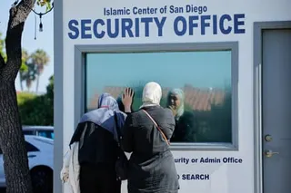 two women cry outside a security office at a mosque