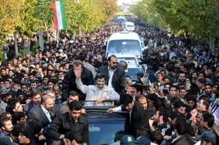 Mahmoud Ahmadinejad is driven past cheering supporters