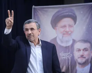 Mahmoud Ahmadinejad gestures to reporters