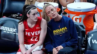 Indiana Fever guards Caitlin Clark and Sophie Cunningham watching basketball game from sidelines