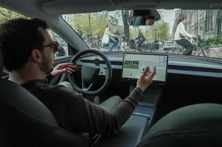 A Tesla owner drives hands-free in Amsterdam on April 17, days after Dutch regulators approved the use of the company’s self-driving software. Photo: Reuters