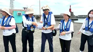 《圖說》大家將魚苗置於水桶中，精準掌握時間、角度與力道接力傳遞，讓魚苗平安回歸大海。（靈鷲山佛教教團提供）