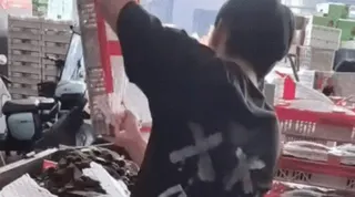 浙江金華一水果市場楊梅滯銷，男子整箱整箱的倒進垃圾桶。（視頻截圖）