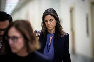A woman looks down while walking in a corridor
