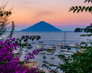 A small volcanic island rising from the sea in the distance.