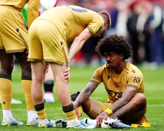 Chris Richards sits on the pitch after injuring his ankle during a Crystal Palace match.