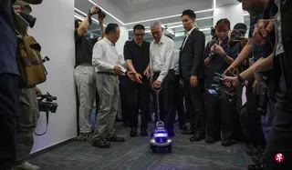 国务资政李显龙（左三），星期四（5月21日）下午参观上海人形机器人创新孵化器时，亲自体验机器人的导盲功能。 （海峡时报）