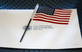An information packet and an American flag are placed on a chair at the U.S. Citizenship and Immigration Services Miami Field Office on Aug. 17, 2018, in Miami. (AP Photo/Wilfredo Lee, File)