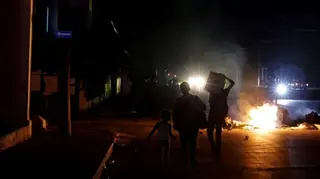 Reuters Three children stand before a burning pile of rubbish in the middle of a road in Havana, the street is completely unlit barring distant car headlights.