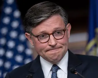 Man in suit grimaces.
