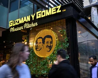 People walk past a Guzman Y Gomez restaurant in Sydney, Australia