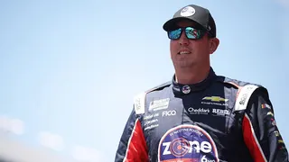 Kyle Busch standing in racing suit at Texas Motor Speedway