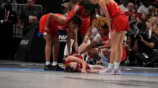 Indiana Fever's Caitlin Clark lying on the basketball court with an injury during a game