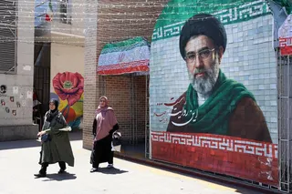 Iranians walking past a picture of the new Iranian supreme leader Ayatollah Mojtaba Khamenei in Tehran on May 18.
