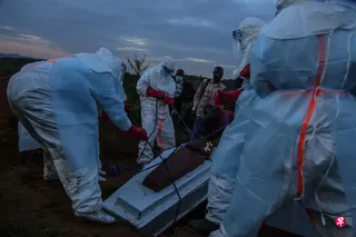 5月21日，身穿个人防护装备的刚果（金）医护人员，把一名死亡的伊波拉患者下葬。 （法新社）