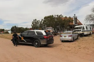 Police vehicles surround a home.