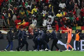 Morocco's Yassine Bounou reacts as fans invade the pitch after Morocco were awarded a penalty following a VAR review in AFCON final