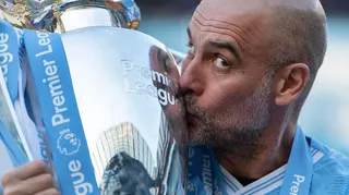 Pep Guardiola kisses the Premier League trophy