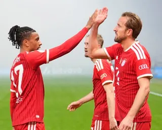Harry Kane and Michael Olise celebrate in the smoky air