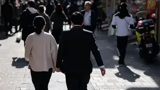 Getty Images A couple walks through a shopping street on February 06, 2026 in Tokyo, Japan.