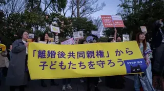 AFP via Getty Images This picture taken on March 29, 2024 shows a group of Japanese women holding a banner saying "Protect children from joint custody after divorce" during a rally outside the National Diet Building in Tokyo against the Japanese government's plan to allow joint custody after divorce.