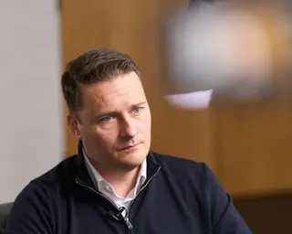 Wes Streeting, in a navy zip-up top over an open-necked white shirt, looks concerned