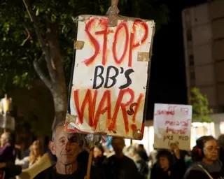 Man holds placard that says Stop BB's war(s)