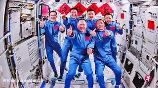 星期一（5月25日）在北京航天飞行控制中心飞控大厅拍摄的神舟21号航天员乘组和神舟23号航天员乘组拍摄合照的实时画面。 （新华社）