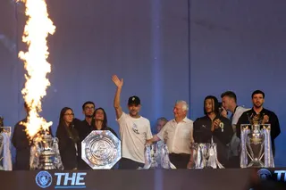 Outgoing coach Pep Guardiola waves as players pose next to all the trophies won over the length of Pep Guardiola's career at City at an after-party event with the players after their victories in the two domestic cup competitions on May 25, 2026, in central Manchester, north-west England. (Photo by Darren Staples / AFP)