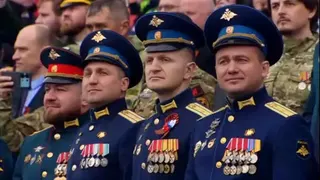 Decorated soldiers watch the parade in Red Square