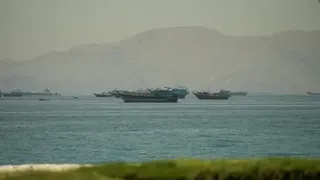 Reuters Boats in the Strait of Hormuz, seen from Oman, with mountains behind