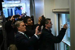 Reporters hold up their phones near a window in the Press Briefing room after a lockdown is triggered by a shooting near  the White House on Saturday. Photo: AFP