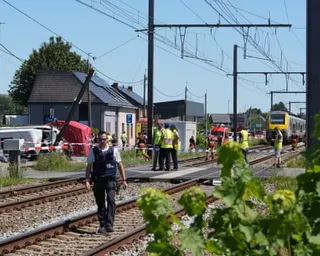 Emergency personnel walk on the railway line