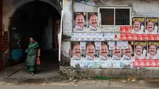 NurPhoto via Getty Images A woman walks out of a residential colony as election campaign posters of United Democratic Front (UDF) candidate Mohammed Shiyaz and Left Democratic Front (LDF) candidate K J Maxy are displayed along a roadside ahead of the Assembly election in Kochi, India, on April 4, 2026.