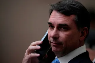 Sen. Flavio Bolsonaro, son of former Brazilian President Jair Bolsonaro, talks on the phone as he arrives for the swearing-in ceremony for justices Nunes Marques and Andre Mendonca as president and vice president of Brazil's Superior Electoral Court in Brasilia, Brazil, Tuesday, May 12, 2026. (AP Photo/Eraldo Peres)