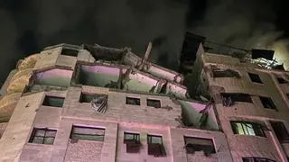 Reuters A block of flats damaged by an air strike pictured at night