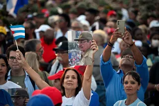A woman holds a photograph of former Cuban president Raul Castro and a Cuban flag during a rally in support of Castro, 94, who has been indicted by a US court, outside the US Embassy in Havana May 22, 2026. — AFP pic