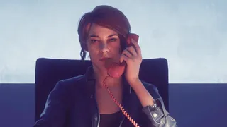 Jesse from Control sits on a chair while on the phone