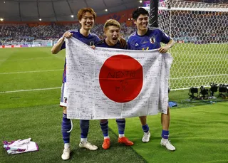 Japan’s Kou Itakura, Ritsu Doan and Takehiro Tomiyasu celebrate with a flag after the match as Japan qualify for the Group E knockout stages against Spain at the Khalifa International Stadium in Doha, Qatar, December 1, 2022. — Reuters file pic