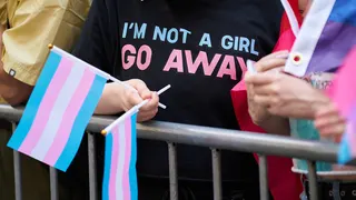 A person displays trans pride flags during the NYC Pride March in New York