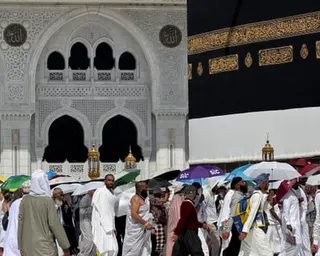 Muslim pilgrims walk through Mecca with sunshades