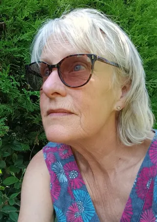 Shirley in front of a hedge.