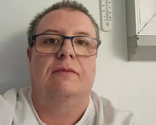 Karl in hospital next to a thermometer.