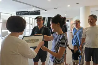 冯慧怡（中间）为张美莹（左一）送上绘有餐馆外观的纪念画。（蔡振鸿摄）