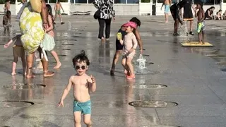 法国出现罕见的5月酷热天气，巴黎不少家长在傍晚带孩子到公园戏水解暑。（图取自法新社）