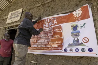 A man hangs an Ebola awareness banner in the Kigonze camp in Bunia, in the eastern Democratic Republic of the Congo on Thursday. Photo: TNS