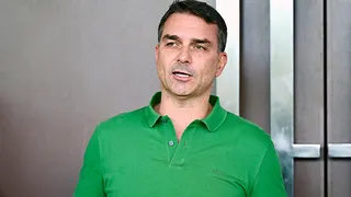 Senator Flávio Bolsonaro speaking at a podium