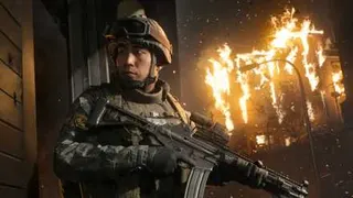 A soldier in Modern Warfare 4 looking behind him while holding an assault rifle with a blazing building burns in the background.